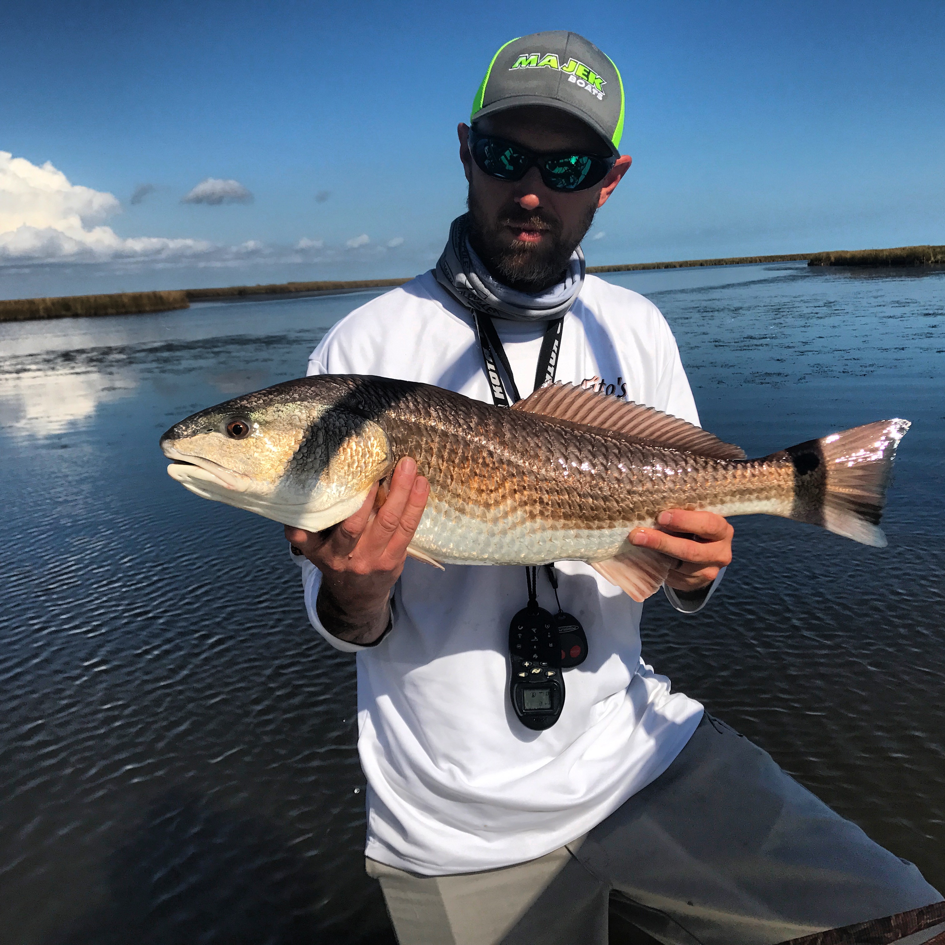 Angler holding a 26-inch redfish caught on Navarre Beach flats