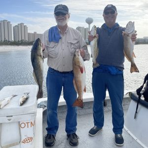 Two anglers holding Redfish and Speckled Trout after a 6-hour fishing charter with Showintail Inshore Charters in Navarre Beach, Florida