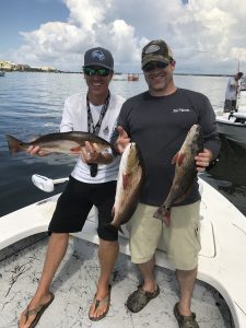 Family posing with a large redfish caught on an inshore charter in Navarre Beach