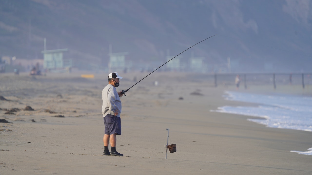 man with fishing rod on the beach