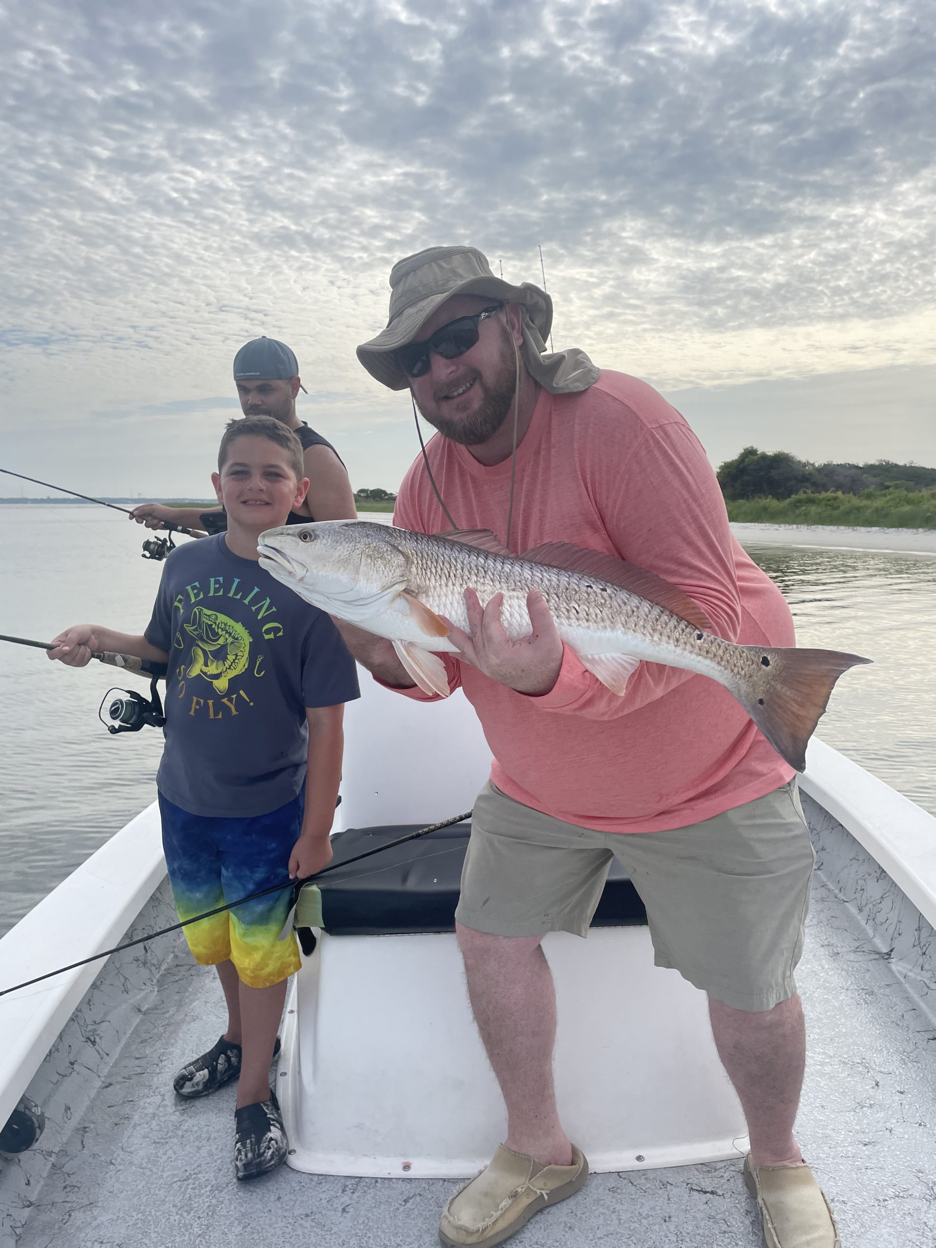 Man holding Redfish with child on boat on Navarre Florida Fishing Charters.