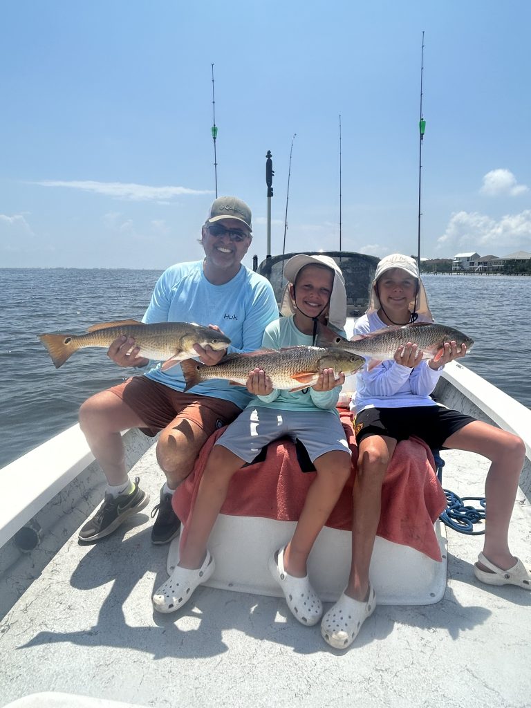 Family Holding Fishing On Boat