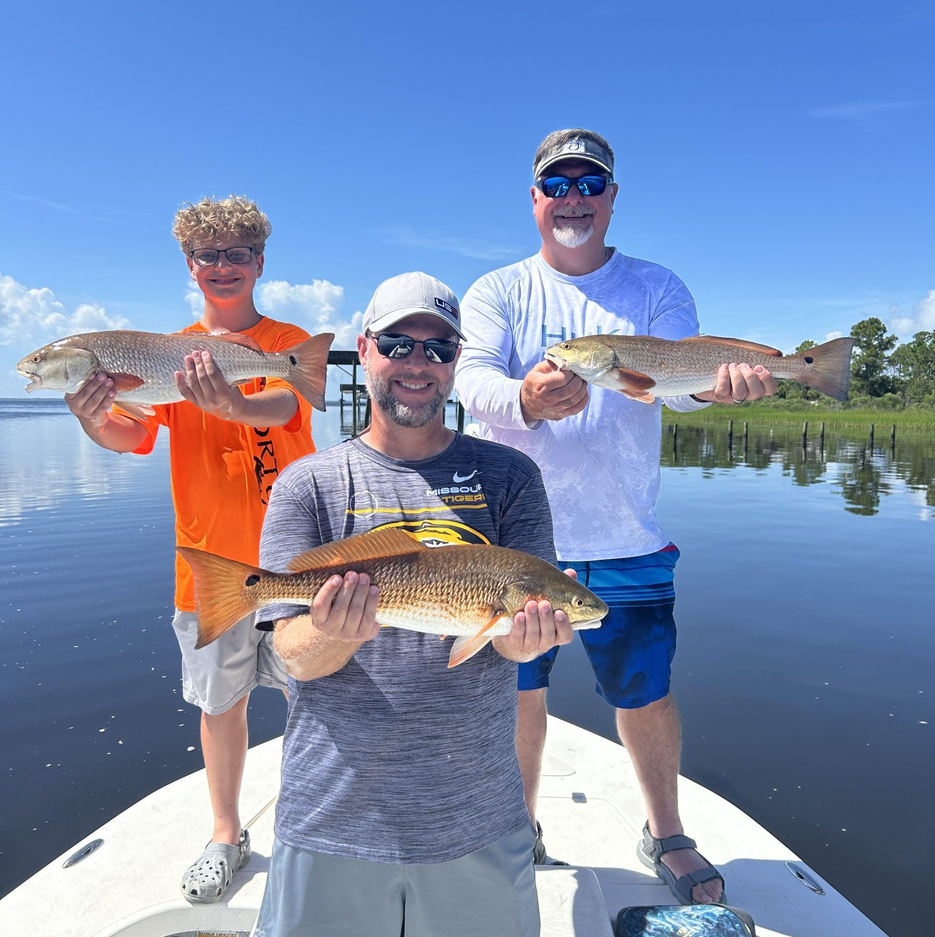 Two anglers holding Redfish and Black Drum during a 4-hour half-day fishing charter with Showintail Inshore Charters in Navarre Beach, Florida