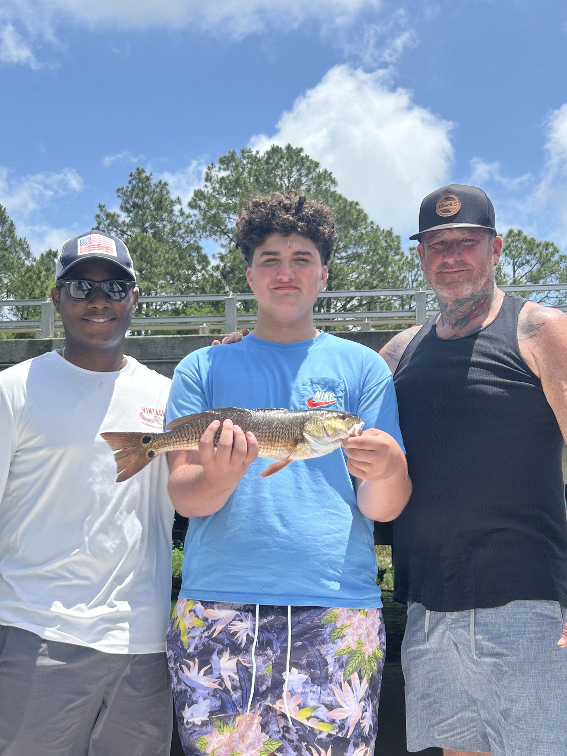 Angler holding a slot redfish caught during a Navarre fishing charter with Showintail
