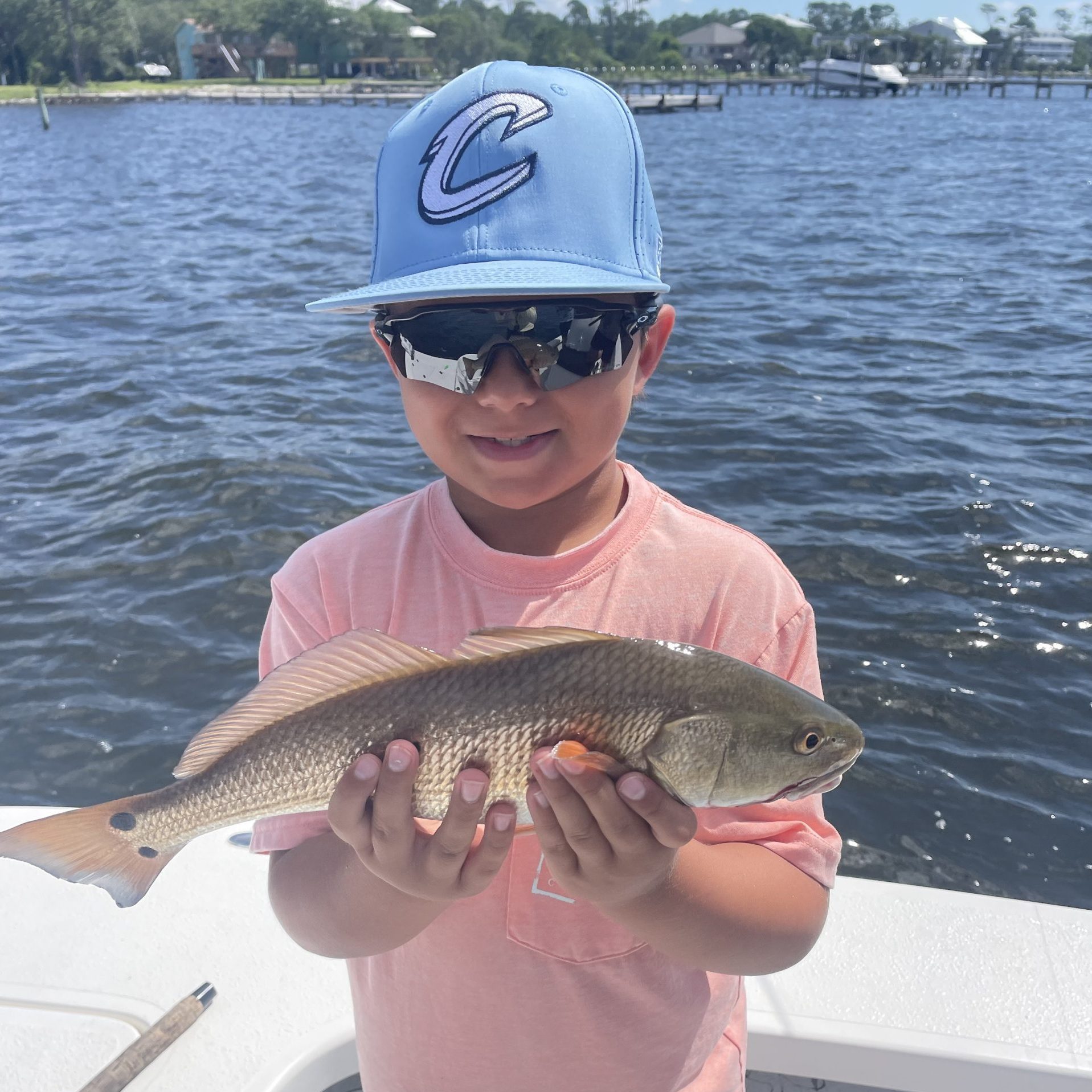 Child reeling in fish on a 2-hour kids fishing charter in Navarre Beach with Showintail Inshore Charters
