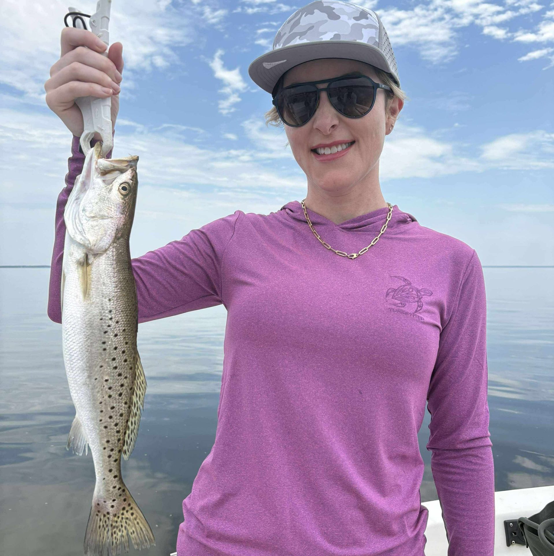 Smiling family holding a redfish during a Mary Esther fishing charter with Showintail Inshore Charters