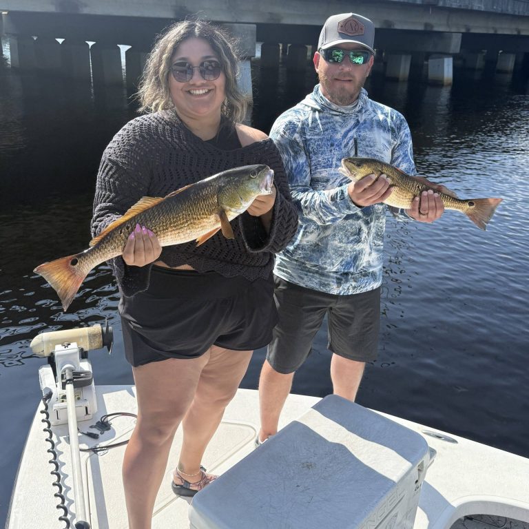 Couple holding a redfish on a private inshore charter