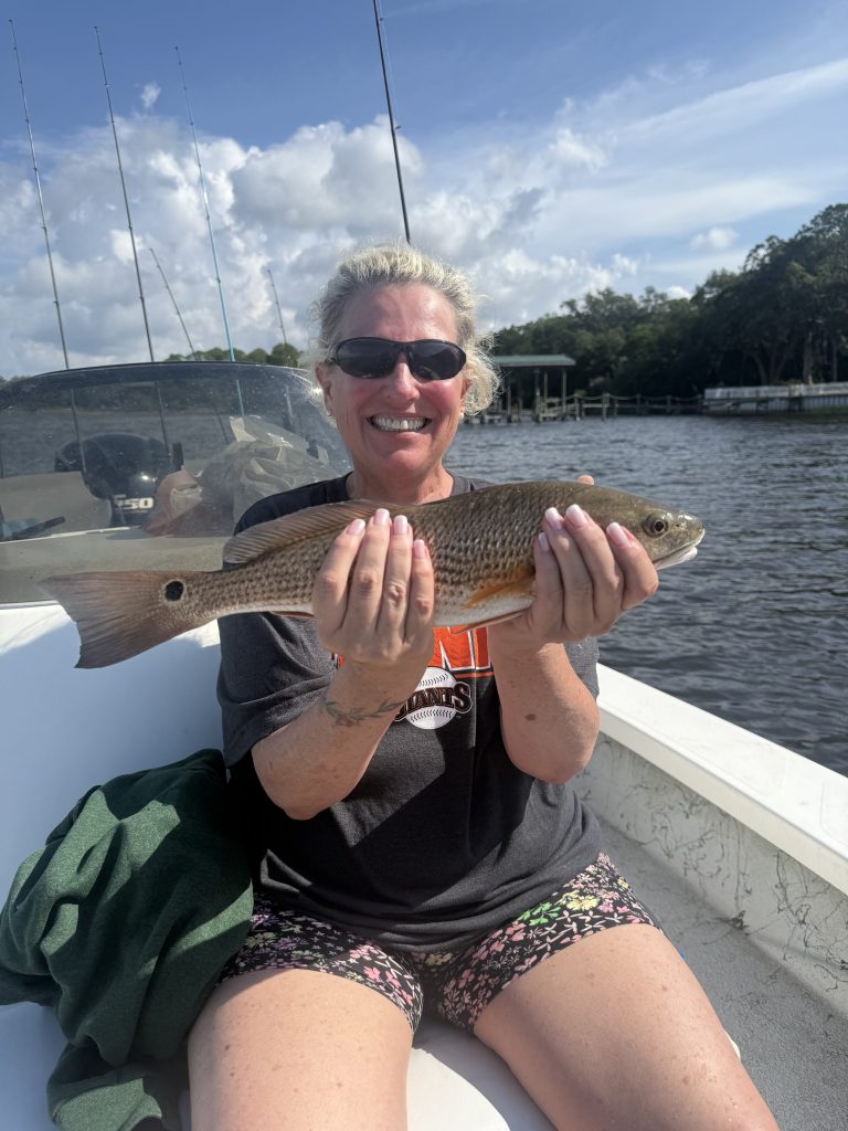 Family fishing on a calm morning in Navarre, Florida catching redfish with Showintail Inshore Charters