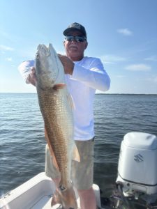 Captain and anglers smiling with fresh catch aboard Showintail Inshore Charters boat