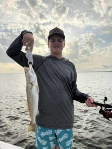Customer holding a freshly caught speckled trout during a Pensacola Beach inshore fishing trip