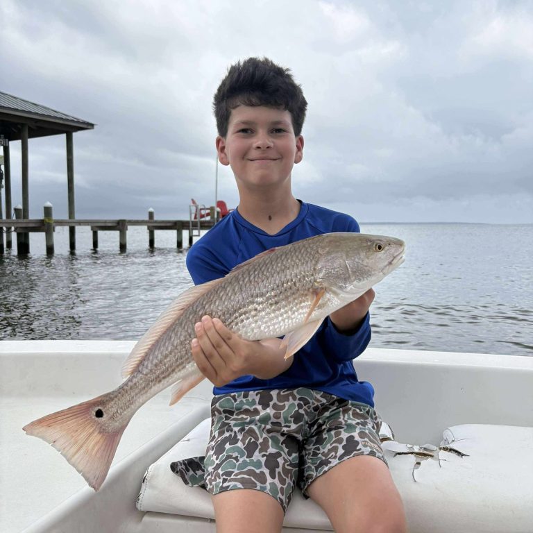 Young angler holding a redfish near Navarre Beach