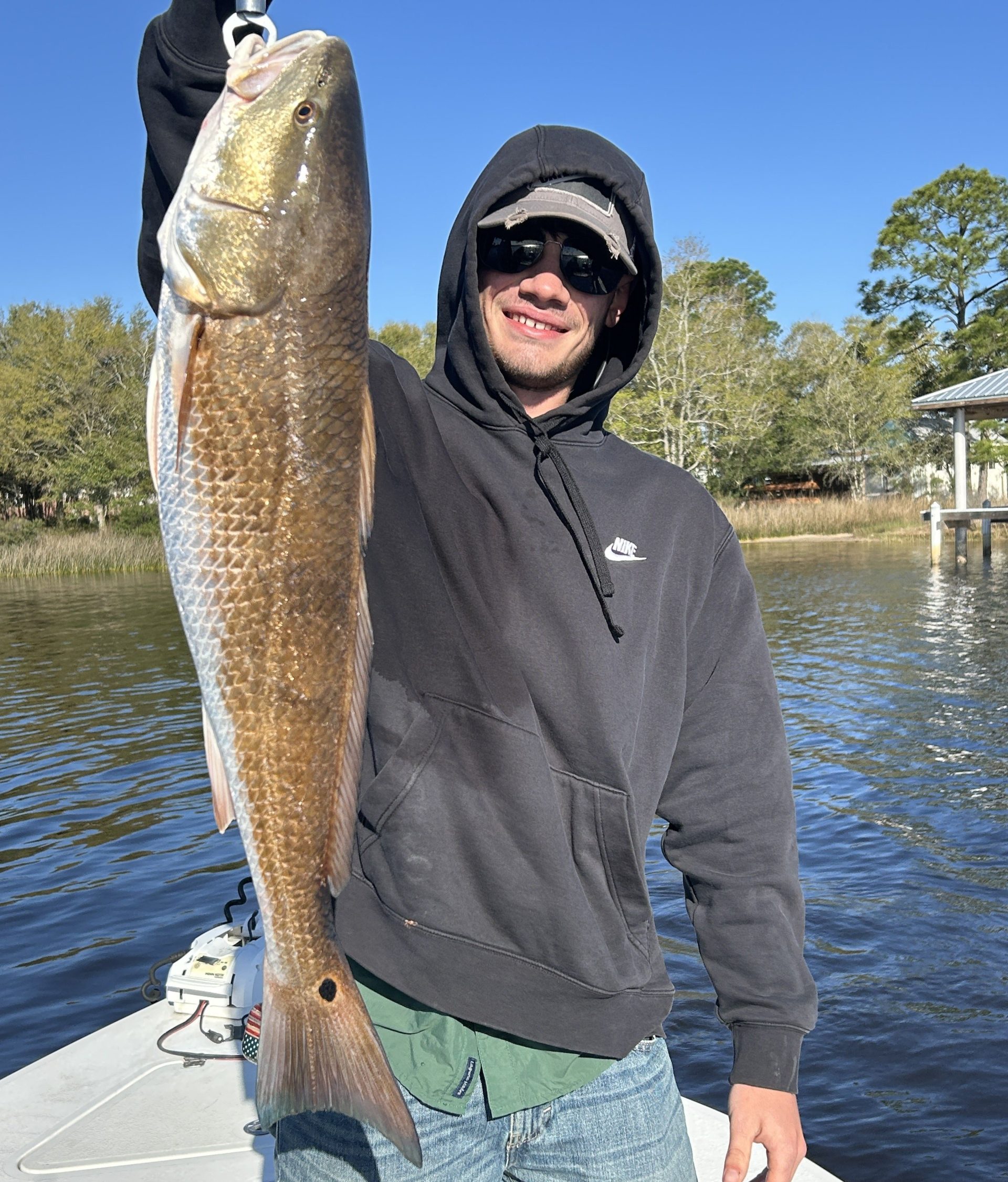 3-hour family fishing charter in Navarre Beach FL with parents and kids holding a redfish